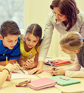 Teacher helping students with classwork 